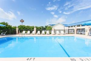 ein großer Pool mit Stühlen und ein Hotel in der Unterkunft Days Inn by Wyndham High Point/Archdale in Archdale