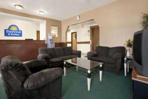 a waiting room with two couches and a tv at Days Inn & Suites by Wyndham Romeoville in Romeoville