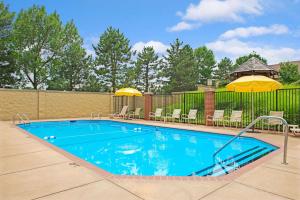 uma grande piscina com cadeiras e guarda-sóis em Days Inn by Wyndham St. Louis/Westport MO em Maryland Heights