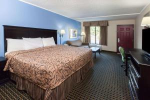 a hotel room with a bed and a desk at Days Inn by Wyndham Norman in Norman