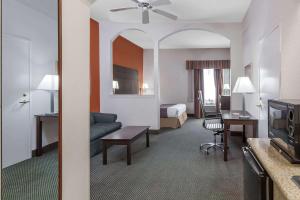 a hotel room with a bed and a living room at Days Inn & Suites by Wyndham Pasadena in Pasadena