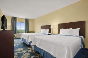 a hotel room with two beds and a television at Days Inn by Wyndham Victoria in Victoria