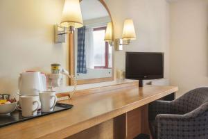 a living room with a television and a coffee table at Days Inn Magor in Magor