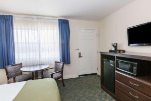 a hotel room with a bed and a table with chairs at Days Inn by Wyndham Santa Maria in Santa Maria