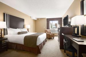 מיטה או מיטות בחדר ב-Days Inn by Wyndham Calgary Northwest