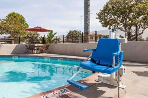 niebieskim krzesłem siedzącym obok basenu w obiekcie Days Inn by Wyndham Santa Maria w mieście Santa Maria