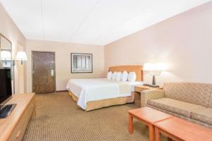 A bed or beds in a room at Days Inn by Wyndham Duluth Lakewalk