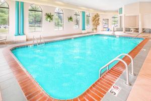 - une grande piscine d'eau bleue dans un bâtiment dans l'établissement Days Inn & Suites by Wyndham Kalamazoo, à Kalamazoo