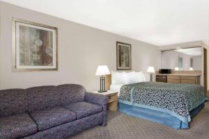 een hotelkamer met een bed en een bank bij Days Inn & Suites by Wyndham Kanab in Kanab