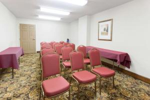 une chambre avec une rangée de chaises et des tables violettes dans l'établissement Days Inn & Suites by Wyndham Tucker/Northlake, à Tucker