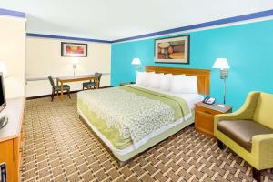 um quarto de hotel com uma cama e uma cadeira em Days Inn by Wyndham Little Rock/Medical Center em Little Rock