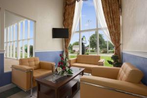 uma sala de espera com sofás, uma mesa e janelas em Days Inn by Wyndham - Cape Cod em West Yarmouth