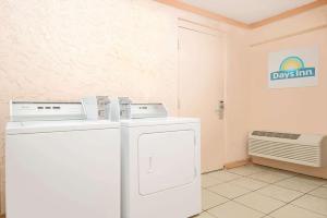 a laundry room with a washer and a dryer at Days Inn by Wyndham Independence in Independence +5 photos