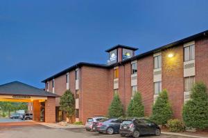 a large brick building with a clock tower on top at Days Inn & Suites by Wyndham Hickory in Hickory