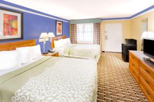 a hotel room with two beds and a flat screen tv at Days Inn by Wyndham Little Rock/Medical Center in Little Rock