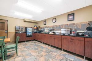 a restaurant kitchen with wooden cabinets and a counter at Days Inn & Suites by Wyndham Baxter Brainerd Area in Baxter