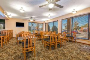 ein Esszimmer mit Tischen und Stühlen und Fenstern in der Unterkunft Days Inn & Suites by Wyndham Albuquerque North in Albuquerque