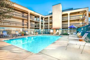 uma imagem de uma piscina num complexo de apartamentos em Days Inn & Suites by Wyndham Albuquerque North em Albuquerque