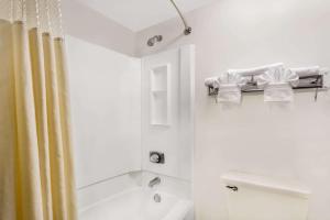 印第安纳波利斯Days Inn by Wyndham Indianapolis Northeast的带浴缸和淋浴的白色浴室