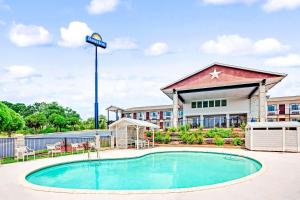 a hotel with a swimming pool in front of a building at Days Inn by Wyndham Boerne in Boerne