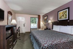 a hotel room with a bed and a television at Days Inn by Wyndham Lugoff in Lugoff