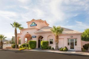 a building with palm trees in front of it at Days Inn by Wyndham Bullhead City in Bullhead City