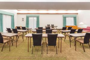 アーリントンハイツにあるDays Inn & Suites by Wyndham Arlington Heightsの部屋にテーブルと椅子が置かれた教室