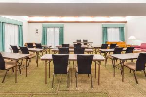 une salle de classe avec des tables et des chaises dans une salle dans l'établissement Days Inn & Suites by Wyndham Arlington Heights, à Arlington Heights