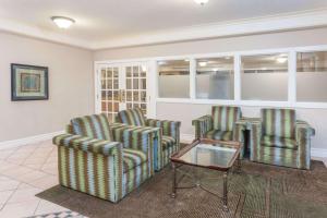 - une salle d'attente avec des chaises et une table dans l'établissement Days Inn & Suites by Wyndham Arlington Heights, à Arlington Heights