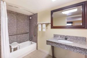 华纳罗宾斯Days Inn & Suites by Wyndham Warner Robins Near Robins AFB的带水槽、浴缸和镜子的浴室