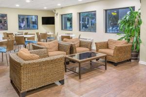 - un hall avec des chaises en osier, une table et une table dans l'établissement Days Inn by Wyndham Biloxi Beach, à Biloxi