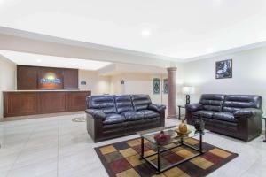 a living room with leather furniture and a stage at Days Inn by Wyndham Indio in Indio