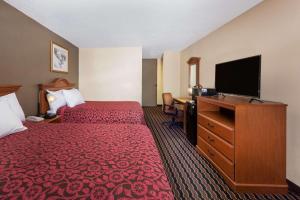 a hotel room with two beds and a flat screen tv at Days Inn by Wyndham Albion in Albion