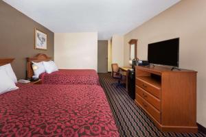 a hotel room with two beds and a flat screen tv at Days Inn by Wyndham Albion in Albion
