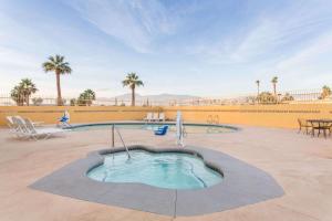 a swimming pool in a courtyard with palm trees at Days Inn by Wyndham Indio in Indio