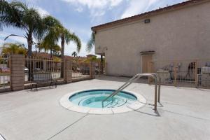 a small swimming pool with a hand rail in a yard at Days Inn & Suites by Wyndham South Gate in South Gate