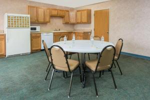 オーセージ・ビーチにあるDays Inn by Wyndham Osage Beach Lake of the Ozarksのテーブルと椅子、冷蔵庫のあるキッチン