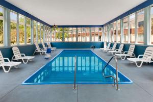 a pool in a room with chairs and a swimming pool at Days Inn by Wyndham Albion in Albion