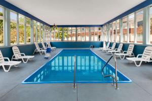 a pool in a room with chairs and a swimming pool at Days Inn by Wyndham Albion in Albion