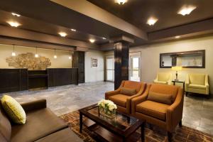 a living room with two couches and a table at Days Inn by Wyndham Innisfail in Innisfail