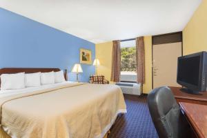 um quarto de hotel com uma cama e uma televisão de ecrã plano em Days Inn by Wyndham Mocksville em Mocksville