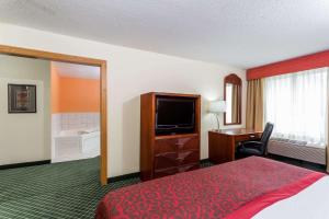 Un pat sau paturi într-o cameră la Days Inn & Suites by Wyndham Bloomington/Normal IL