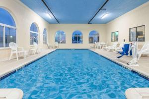 a pool with chairs and chairs in a large room with windows at Days Inn by Wyndham Miami in Miami