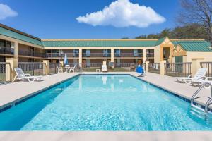 a pool at a resort with chairs and a building at Days Inn by Wyndham Mocksville in Mocksville