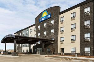 a building with a sign on top of it at Days Inn by Wyndham Calgary North Balzac in Balzac