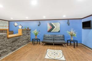 un soggiorno con divano e parete blu di Days Inn by Wyndham Lavonia a Lavonia