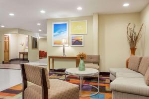 a waiting room with a couch and a table at Days Inn & Suites by Wyndham Bloomington/Normal IL in Bloomington