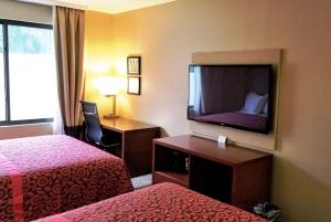 a hotel room with a flat screen tv and a bed at Days Inn by Wyndham Brooklyn Marine Park in Brooklyn