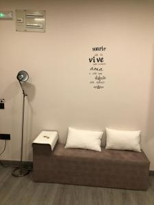 Sofá con 2 almohadas en una habitación con lámpara en Madala XXI, en Oviedo