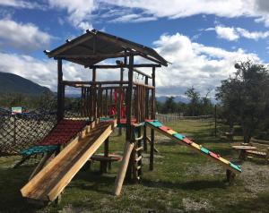 un parque infantil con tobogán y columpio en Cabañas La Querencia Tolhuin en Tolhuin